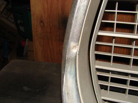 1973 Ford Ranchero - Close-up of dented chrome trim and a portion of a vehicle grille.