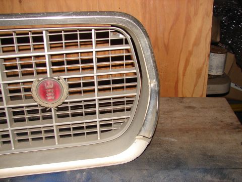 1973 Ford Ranchero - A close-up of a vehicle's front grille, a circular red emblem with white lettering.