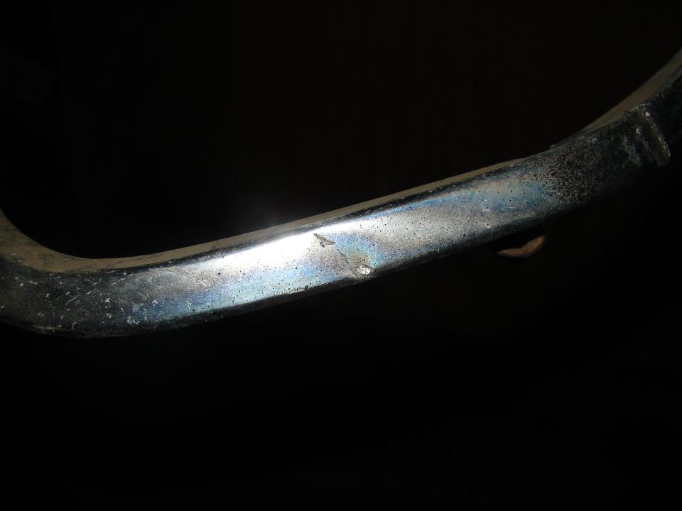 Chrome trim piece with a small dent and discoloration
