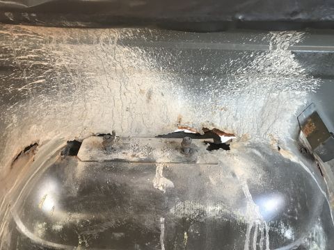 1992 Ford Bronco - The undercarriage shows significant rust and damage, with white residue splattered on the metal.