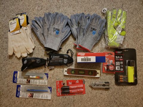 1965 Ford Mustang - Various tools and safety gear are laid out on a carpeted floor, including multiple pairs of gloves and a level.
