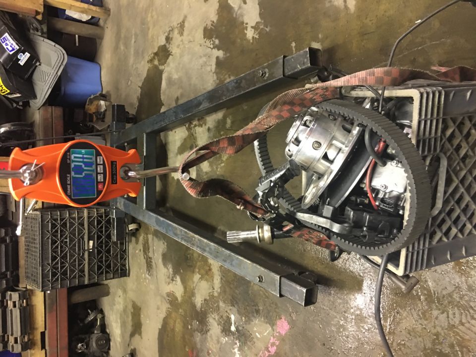 Transmission being weighed on an orange digital scale with a black belt