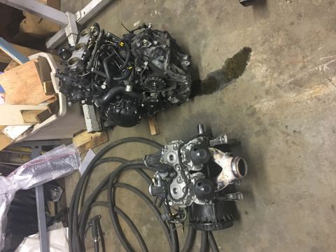2000 Ford E350 - Disassembled engine components are laid out on a workshop floor, with one engine showing a fluid leak.