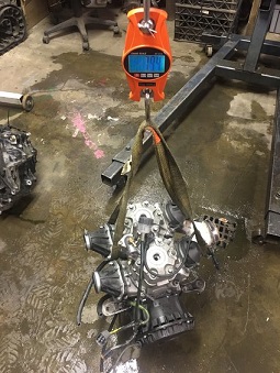 2000 Ford E350 - An engine is weighed in a workshop environment, with other parts visible in the background.