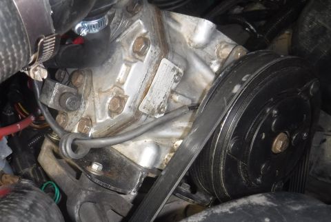 1992 Ford Bronco - Mounted! With a whisker of daylight to spare below the intake tube and alongside the crank case vent tube! Three of the four stock A/C bolt…