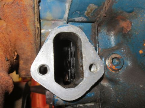 1967 Ford F-250 - A close-up view of an engine component, showing its metallic texture and surrounding rust and blue paint.