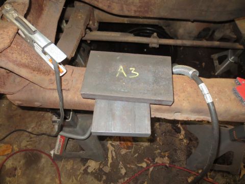 1967 Ford F-250 - A welding clamp is attached to a rusty frame, with metal plates labeled 'A3' positioned above another plate.