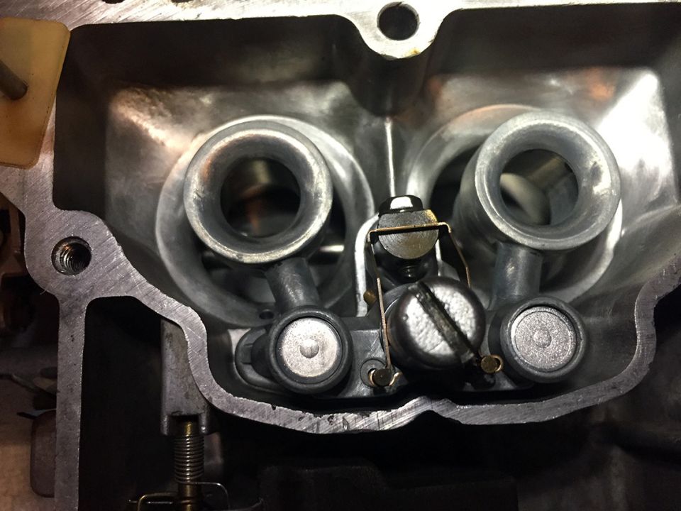 Carburetor interior with two intake ports, throttle plates, and adjustment screws