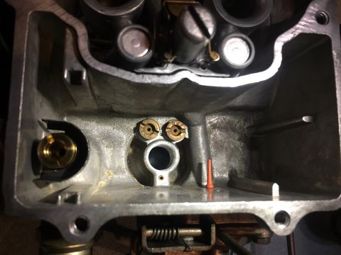 1978 Ford Bronco - Close-up view of the internal components of a carburetor, showing brass jets and other mechanical parts.