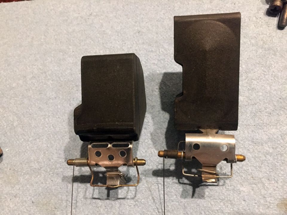 two carburetor parts side-by-side on a gray surface