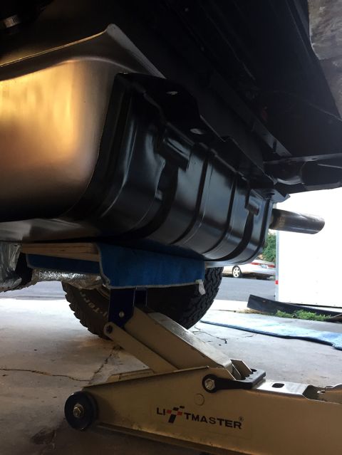 1978 Ford Bronco - Underside view of a vehicle's fuel tank and exhaust system being worked on.