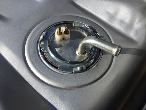 1978 Ford Bronco - Close-up of a fuel tank sending unit, showing the metal fuel line and electrical terminals.