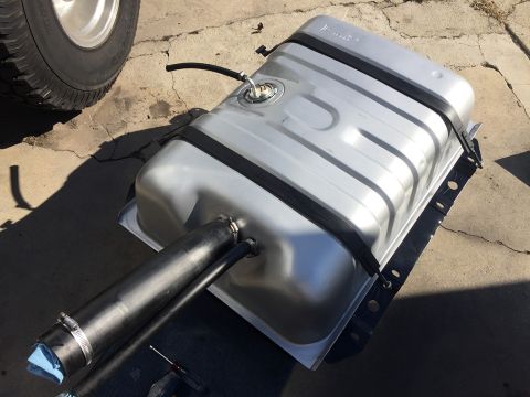 1978 Ford Bronco - Aftermarket fuel tank and a tire are shown on a concrete surface.
