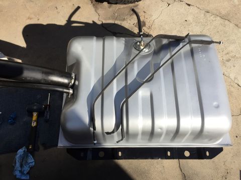 1978 Ford Bronco - A silver fuel tank with attached lines and straps is shown on a concrete surface, with tools nearby.