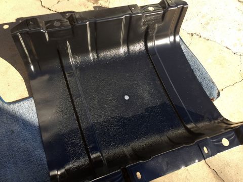 1978 Ford Bronco - Black metal skid plate with mounting holes and textured surface, possibly for a vehicle's undercarriage.
