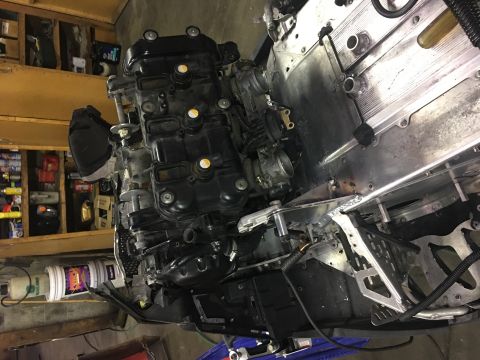 2000 Ford E350 - Engine and chassis components are shown in a workshop setting, with shelves of supplies in the background.