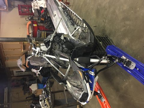 2000 Ford E350 - A snowmobile's front end is shown with its blue skis and engine parts visible, suggesting it is a part or in a state of repair.
