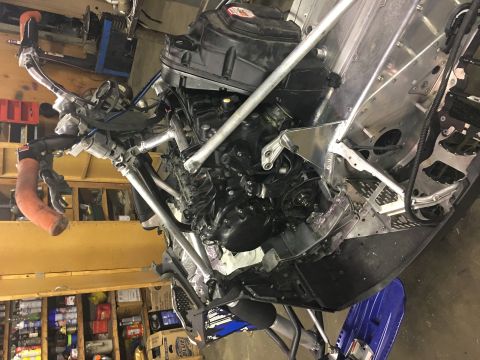 2000 Ford E350 - Close-up view of a snowmobile's engine and chassis components during maintenance or repair.