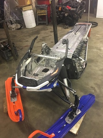 2000 Ford E350 - A snowmobile chassis is shown in a workshop setting, with its front end and skis visible.