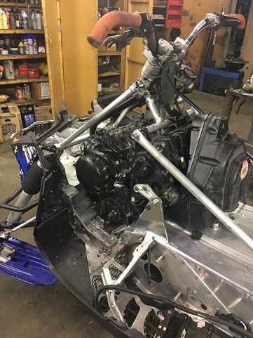 2000 Ford E350 - Close-up view of a snowmobile's engine and frame, with handlebars visible.