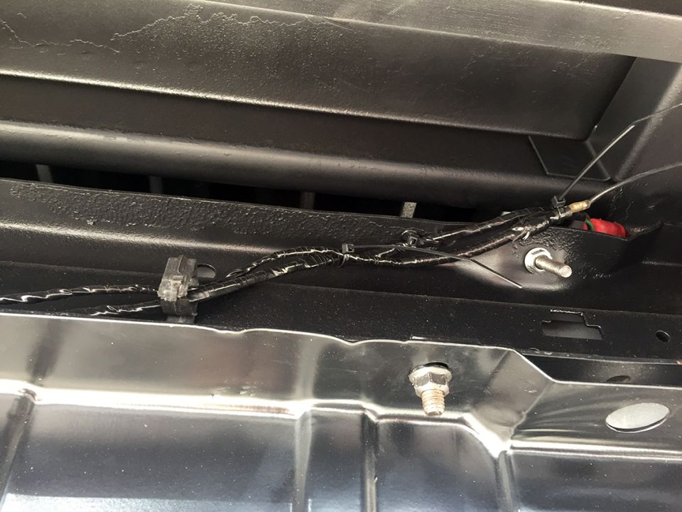 Wiring harness secured with clips under a black surface