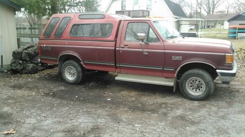 1991 Ford F-150 - Maroon 1991 Ford F-150 pickup truck with a red camper shell is parked in a gravel driveway.