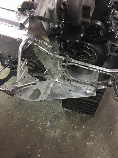 2000 Ford E350 - Custom fabricated metal part with engine components, likely for a performance vehicle or custom build.