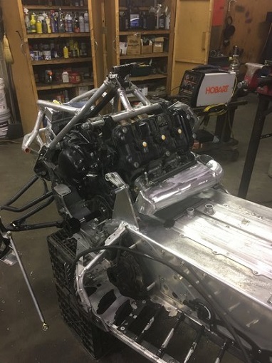 2000 Ford E350 - A snowmobile chassis is shown with a large engine mounted, in what appears to be a workshop setting.