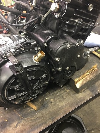 2000 Ford E350 - A detailed view of a black engine part, possibly from a motorcycle, resting on a workbench.
