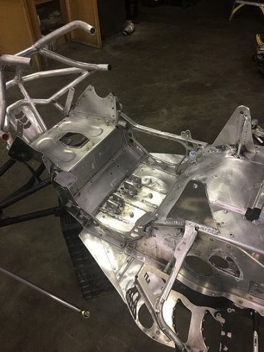 2000 Ford E350 - Unfinished aluminum snowmobile chassis frame with various metal components and suspension attachments.