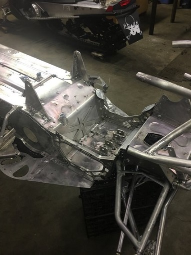 2000 Ford E350 - Shop scene with a snowmobile chassis in the foreground and another snowmobile in the background.