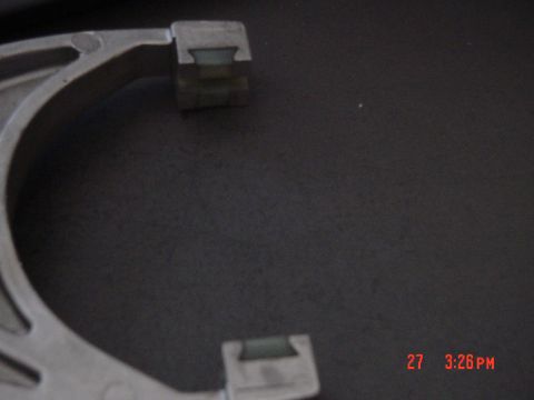 1987 Ford Bronco - A metal part with green inserts is shown in a close-up view, with Supermotors.net branding visible.