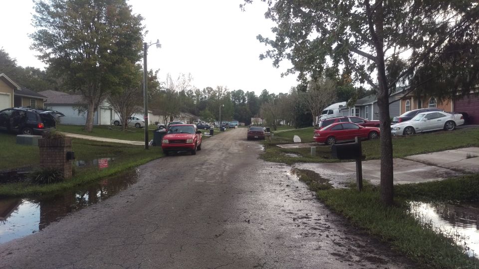 Red 2006 Honda RANCHER pickup truck parked on a flooded street