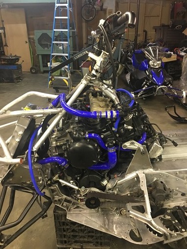 2000 Ford E350 - Close-up of a snowmobile's engine and chassis, with another snowmobile visible behind it.