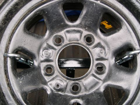1986 Ford Bronco - Close-up of a spare tire mount with visible metal straps and eye bolts.