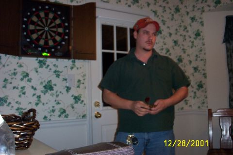 1979 Ford F-150 - Man holding darts in a room with a dartboard on the wall.