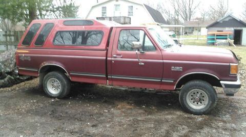1991 Ford F-150 - This pickup truck is equipped with a camper shell and has '4x4' badging on the rear fender.
