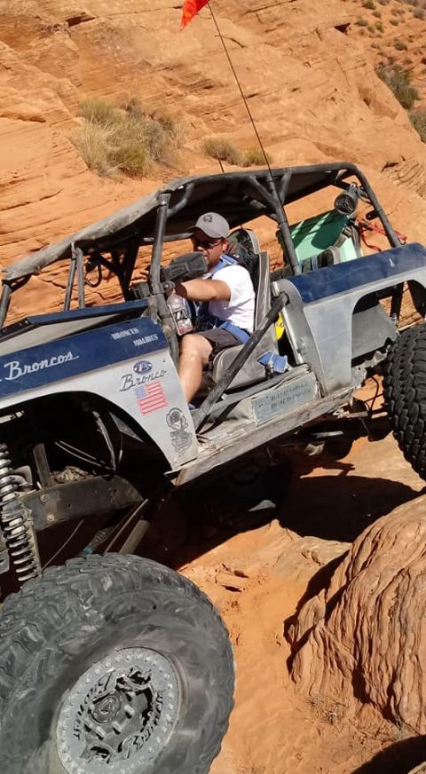 1979 Ford Bronco - A modified 1979 Ford Bronco navigates a challenging off-road course with a driver and passenger inside.