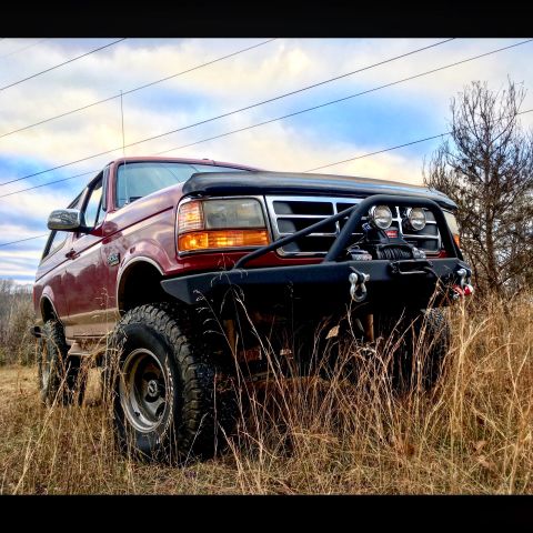 1995 Ford Bronco - Modified 1995 Ford Bronco sits in a field, equipped with a winch and heavy-duty bumper.