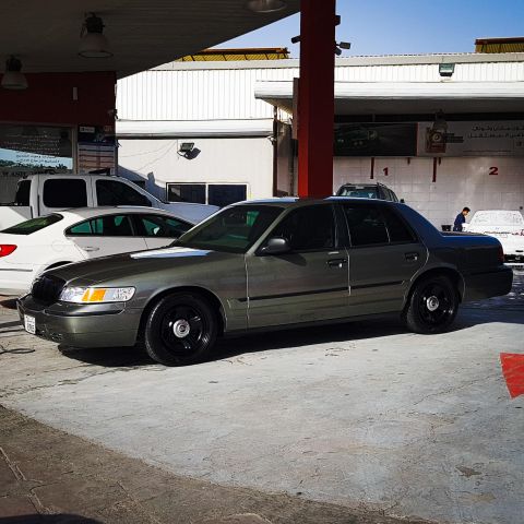 2001 Mercury Grand Marquis - A gray 2001 Mercury Grand Marquis is seen at a car wash with other vehicles in the background.