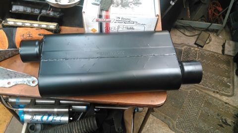 1978 Ford Bronco - A black muffler sits on a table, with a box indicating it is for a 72 Bronco.