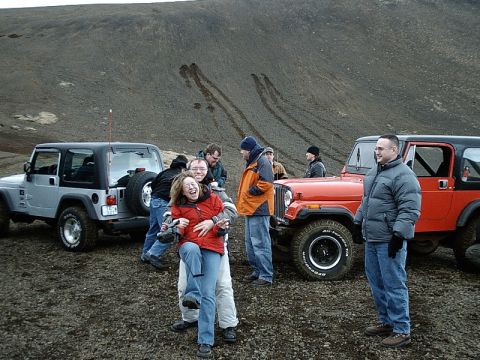 1996 Ford Bronco - A group of people stand around two Jeep Wranglers in a rocky, barren landscape.