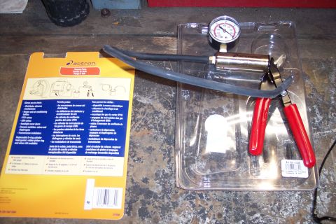 1995 Ford Bronco - Actron vacuum pump and gauge kit, likely for automotive diagnostics, shown with its packaging.