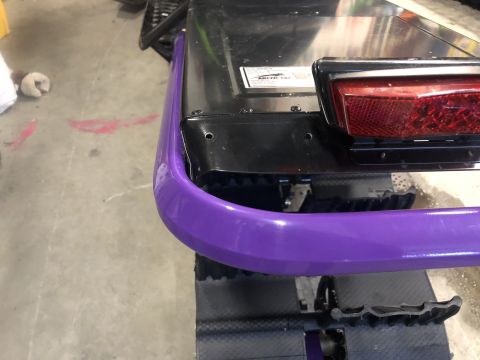 2019 Arctic Cat Mountain Cat 800 - Close-up of the rear section of a snowmobile, showing a purple bumper and taillight assembly.