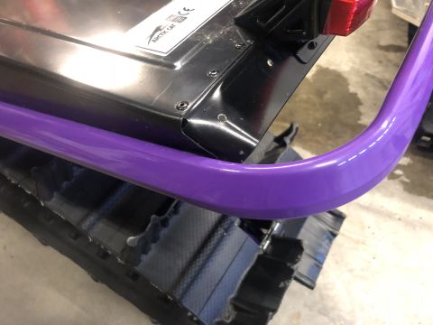 2019 Arctic Cat Mountain Cat 800 - Close-up view of a snowmobile's rear section, showing a purple bumper and track with an Arctic Cat logo.