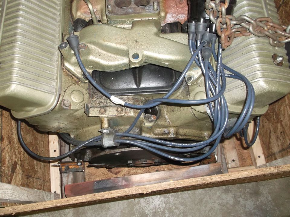 Engine block with gold valve covers, spark plug wires, and a chain attached