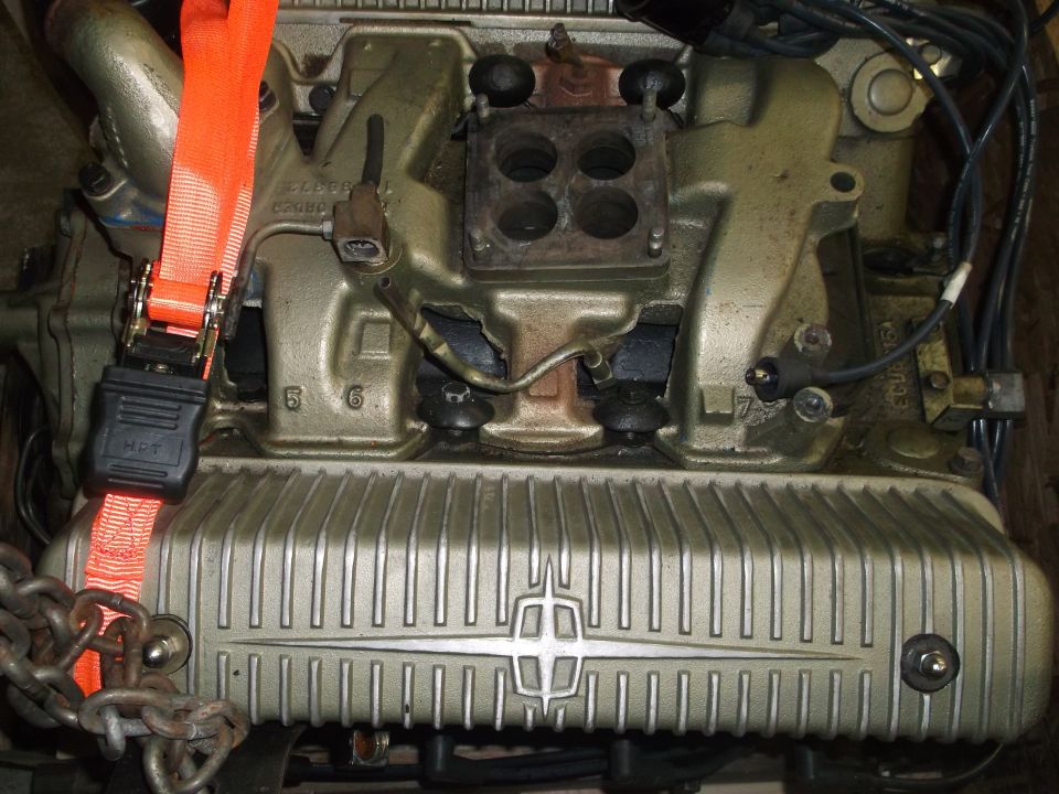 Engine intake manifold and valve cover with Lincoln emblem. Ratchet strap attached