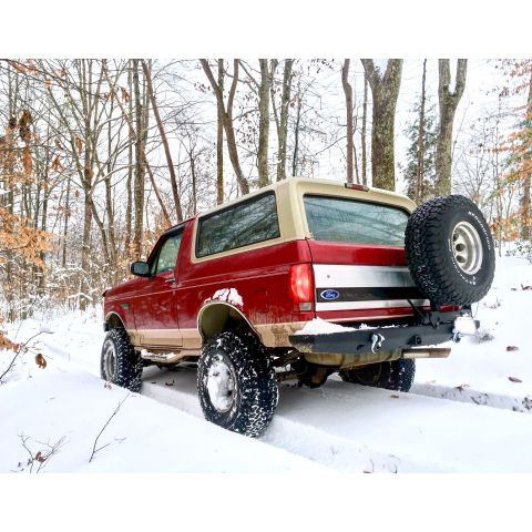 1995 Ford Bronco - This 1995 Ford Bronco navigates a snowy forest road with its rear tire visible.