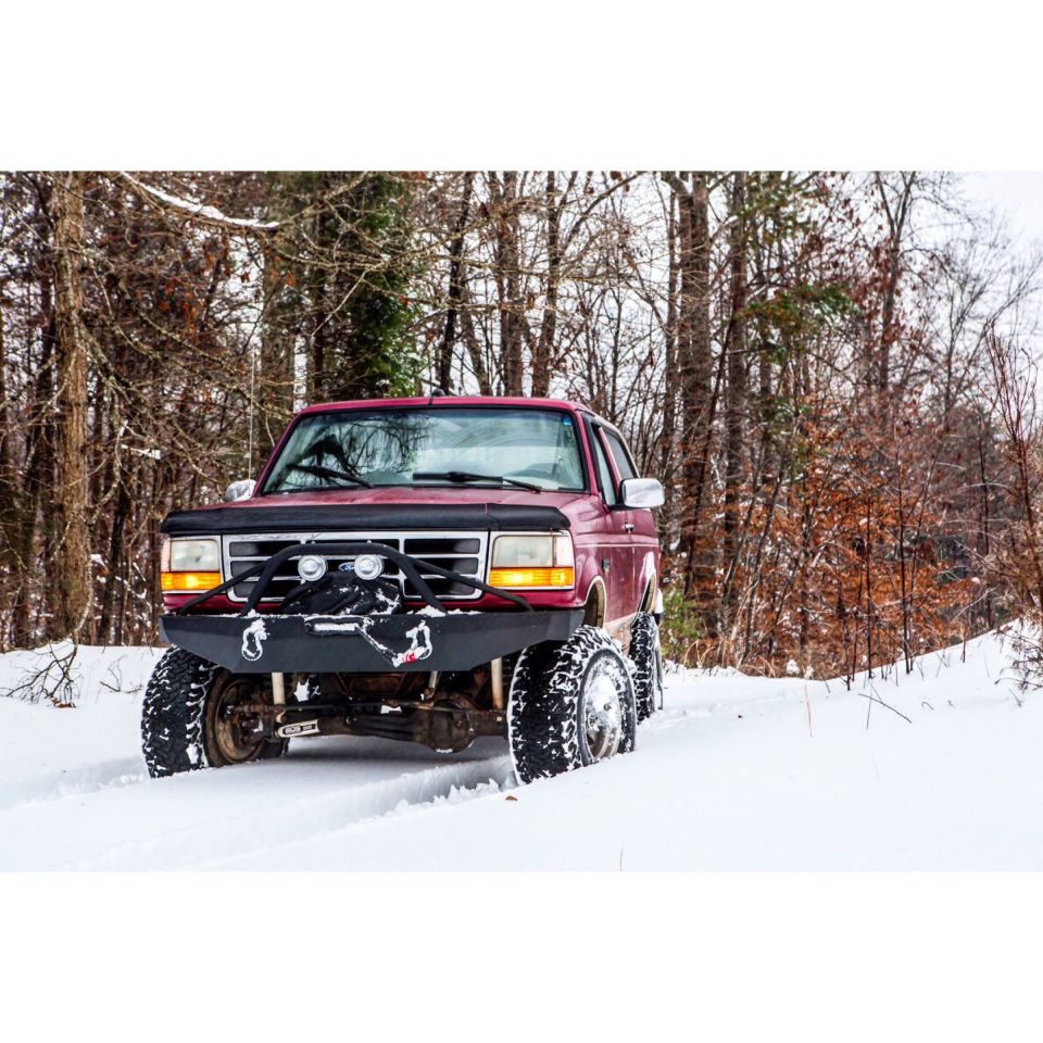 1995 Ford Bronco with aftermarket bumper driving in snow