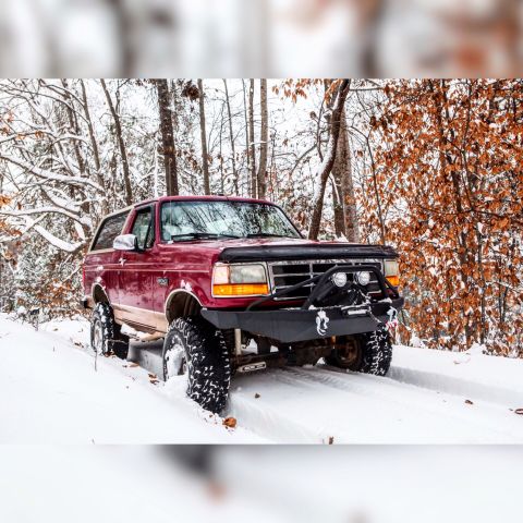 1995 Ford Bronco - 1995 Ford Bronco navigating a snowy forest road.